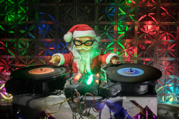 Christmas and New Year club concept. Dj mixer with headphones on snow. Santa Claus is mixing on...