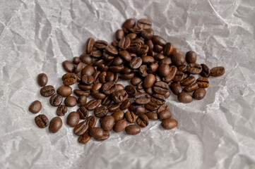 Fresh aromatic roasted coffee beans on craft paper. Arabica and robusta blend