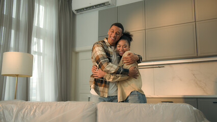 Happy male female home owners African American family moving in new house relocation cheerful woman...