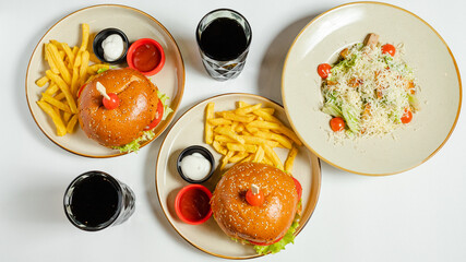 Club sandwich, Burger and fries on plates top view