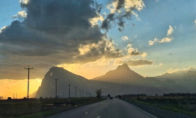 Photo of an empty road leading to large mountains