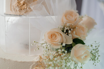 Elegant Wedding Cake Surrounded by Delicate Roses and Baby's Breath