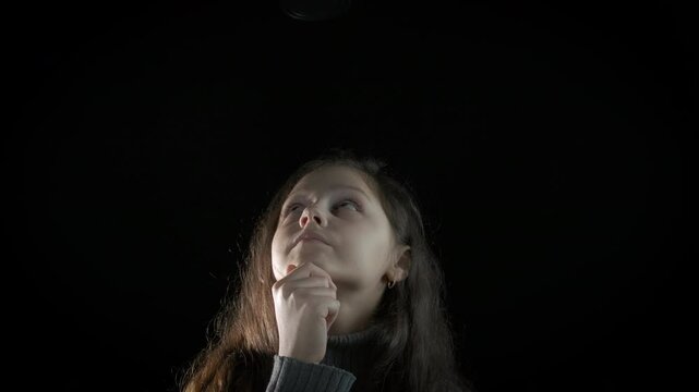 Educated teen with bulb. View of smart little girl with great ide with lantern on the black background.