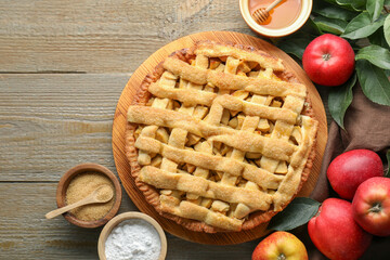 Flat lay composition with tasty homemade apple pie and ingredients on wooden table