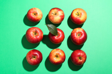 Red apples and seeds on green background, flat lay