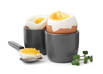 Soft boiled eggs and spoon isolated on white