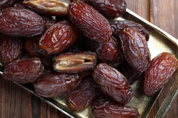 Many tasty dried dates on wooden table, top view