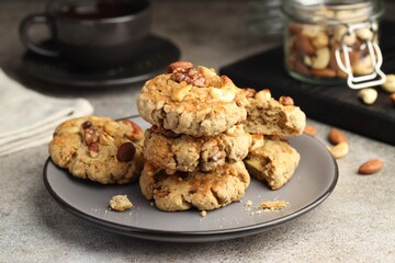 Tasty cookies with nuts on gray textured table, closeup