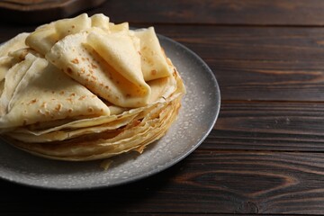 Tasty crepes on wooden table, closeup. Space for text