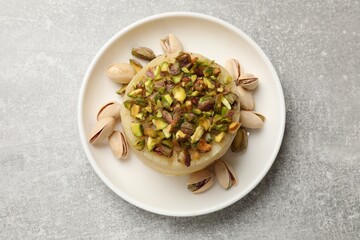 Delicious sweet semolina halva with pistachios on light grey table, top view