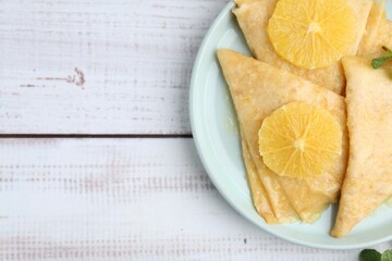 Delicious Crepes Suzette on white wooden table, top view. Space for text