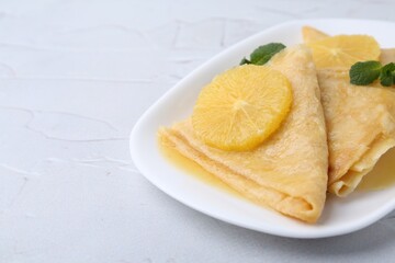Delicious Crepes Suzette on white textured table, closeup. Space for text