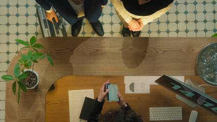 Top view concierge meet guests welcome hotel reception muslim couple tourists travelers arrive resort journey vacation travel abroad administrator check passports give key card booking room service