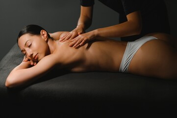 Masseur doing massage on woman back in the spa salon