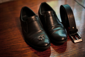 Elegant Groom's Accessories: Stylish Shoes, Band Rings, and a Leather Belt