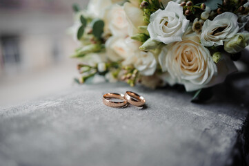 Elegant Wedding Rings Beside a Beautiful Floral Bouquet