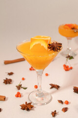 Orange juice in high glass with orange cube and spices