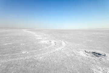 Surface of the lake covered with snow or salar. Landscape of a deserted salt lake or plains. texture of salt formations in the foreground. salt lake surface, dry salt lake