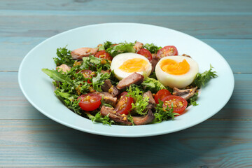 Delicious fresh tuna salad on light blue wooden table, closeup