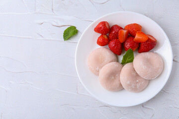 Delicious mochi and strawberries on white table, top view. Space for text