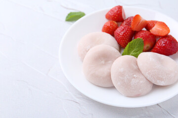 Delicious mochi and strawberries on white table, closeup
