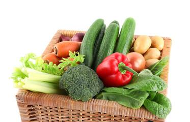 Different ripe vegetables in wicker box isolated on white