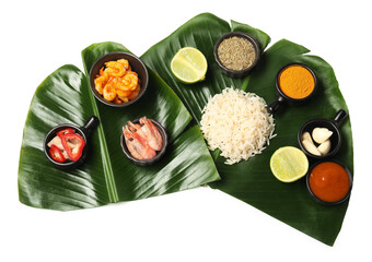 Cut banana leaves with different food, spices and sauce isolated on white, top view. Healthy eco serving