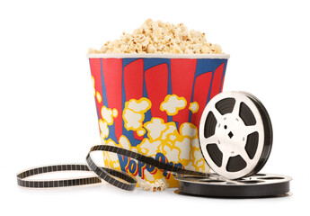 Tasty popcorn and film reels isolated on white