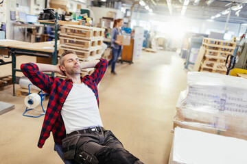 Worker relaxing in manufacturing facility after completing tasks