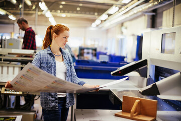 Female worker reviewing prints in a factory