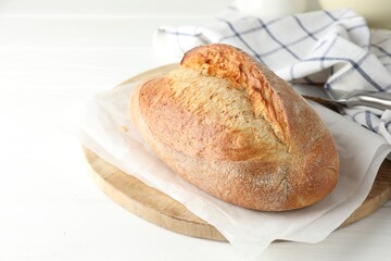 Loaf of delicious bread on white wooden table, closeup