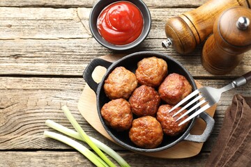 Tasty meatballs in baking dish served on wooden table, flat lay