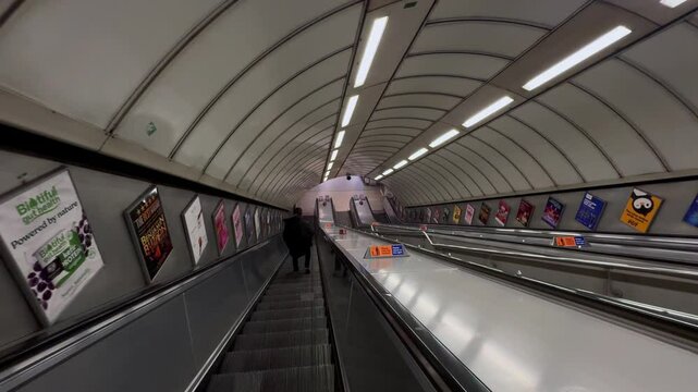 People walking down the escalator at an underground station in London
