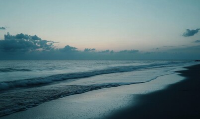 A serene beach at twilight with gentle waves and soft clouds.