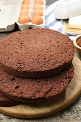 Cut chocolate sponge cake and ingredients on wooden table, closeup