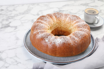 Freshly baked sponge cake and coffee on white marble table