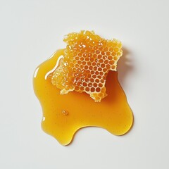 A honeycomb is on a white background with a drop of honey on it