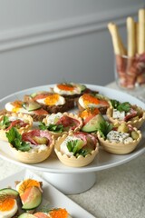 Many different tasty canapes on white table, closeup