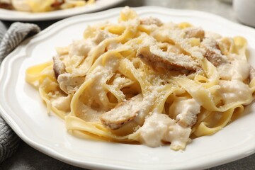 Tasty Alfredo pasta with chicken on table, closeup