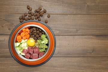Dry pet food and natural products on wooden table, top view. Space for text