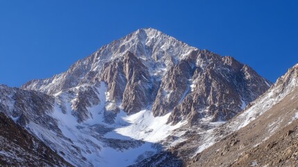 Majestic Snow-Capped Mountain Peak Under Clear Blue Sky