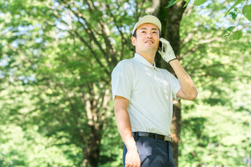 ゴルフ場でスマホを使う男性ゴルファー（アプリ・スコア・スコア管理・コース戦略・コースマップ）
