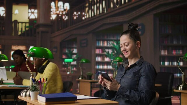 Noisy person disturbing people at the library by speaking very loud, being rude and answering a phone call in the study area. Disruptive annoying woman asked to keep silence. Camera A.