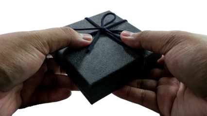 Black gift box with texture with black ribbon isolated on transparent background background. Black box being held in hand. transparent object