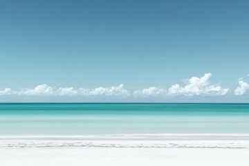 A tranquil beach scene with clear turquoise waters and a blue sky.