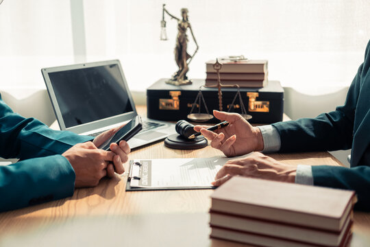 Businesses and lawyers are discussing contract documents and legal entities in law firms and are examining legal documents with the hammer and scales of justice. which is a symbol of the law