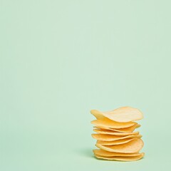 Minimalist Stack of Potato Chips on Pale Green Background - Modern Snack