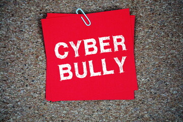 Cyber Bully text message on stick note on cork paper background