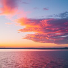 Fototapeta premium A breathtaking sunset paints the sky with vibrant pink, orange, and purple hues, reflected beautifully on the tranquil ocean surface. Clouds add texture to the colorful spectacle.
