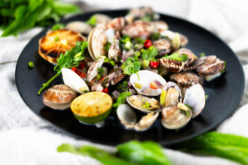 A vibrant seafood dish showcasing clams, mussels, and garlic, garnished with green herbs.